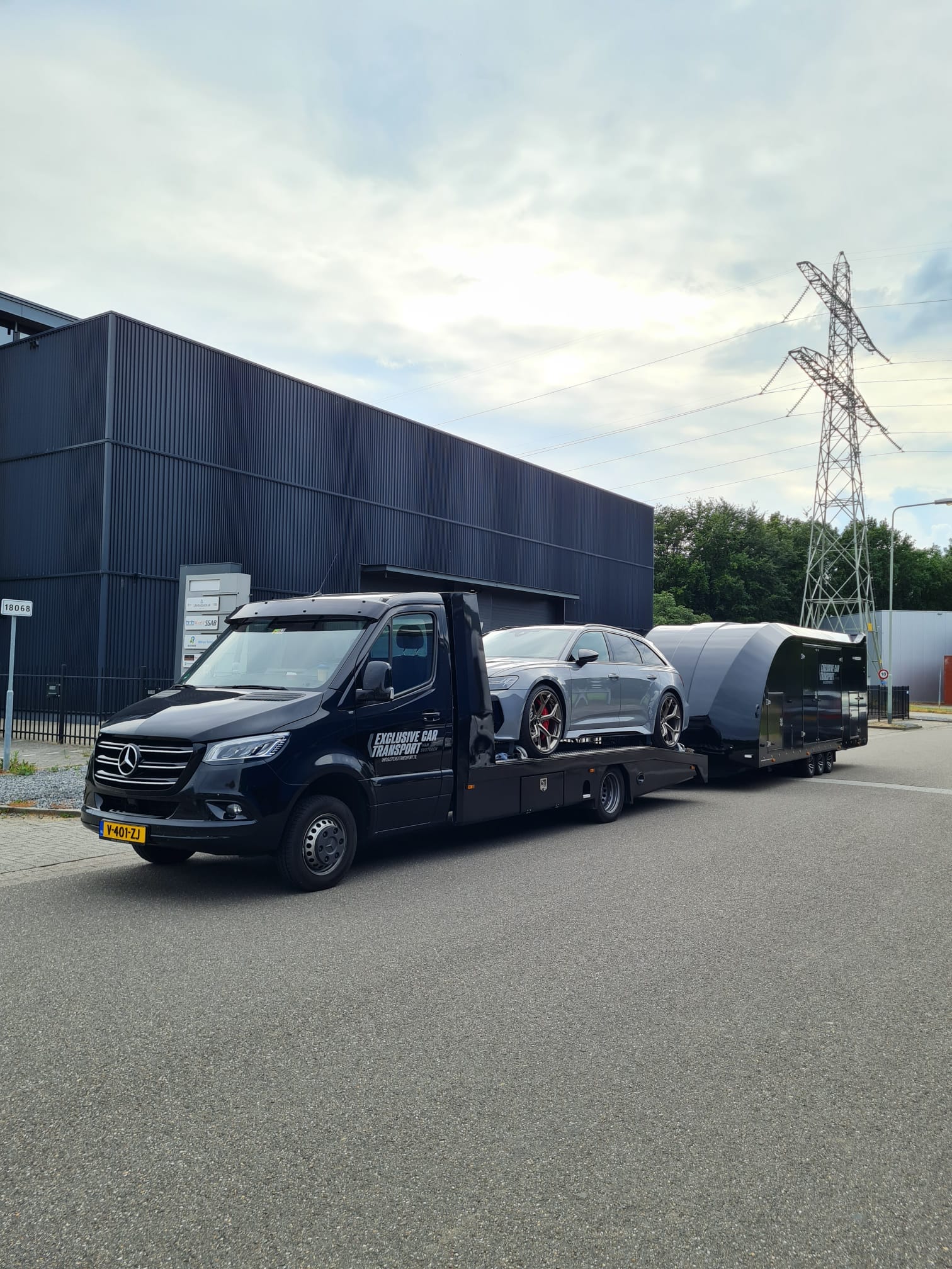Zwarte Mercedes Sprinter met een grijze Audi RS6 Avant op de laadbak